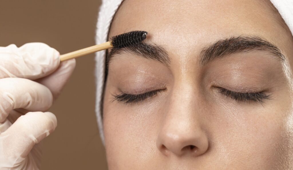 woman doing eyebrow treatment her client